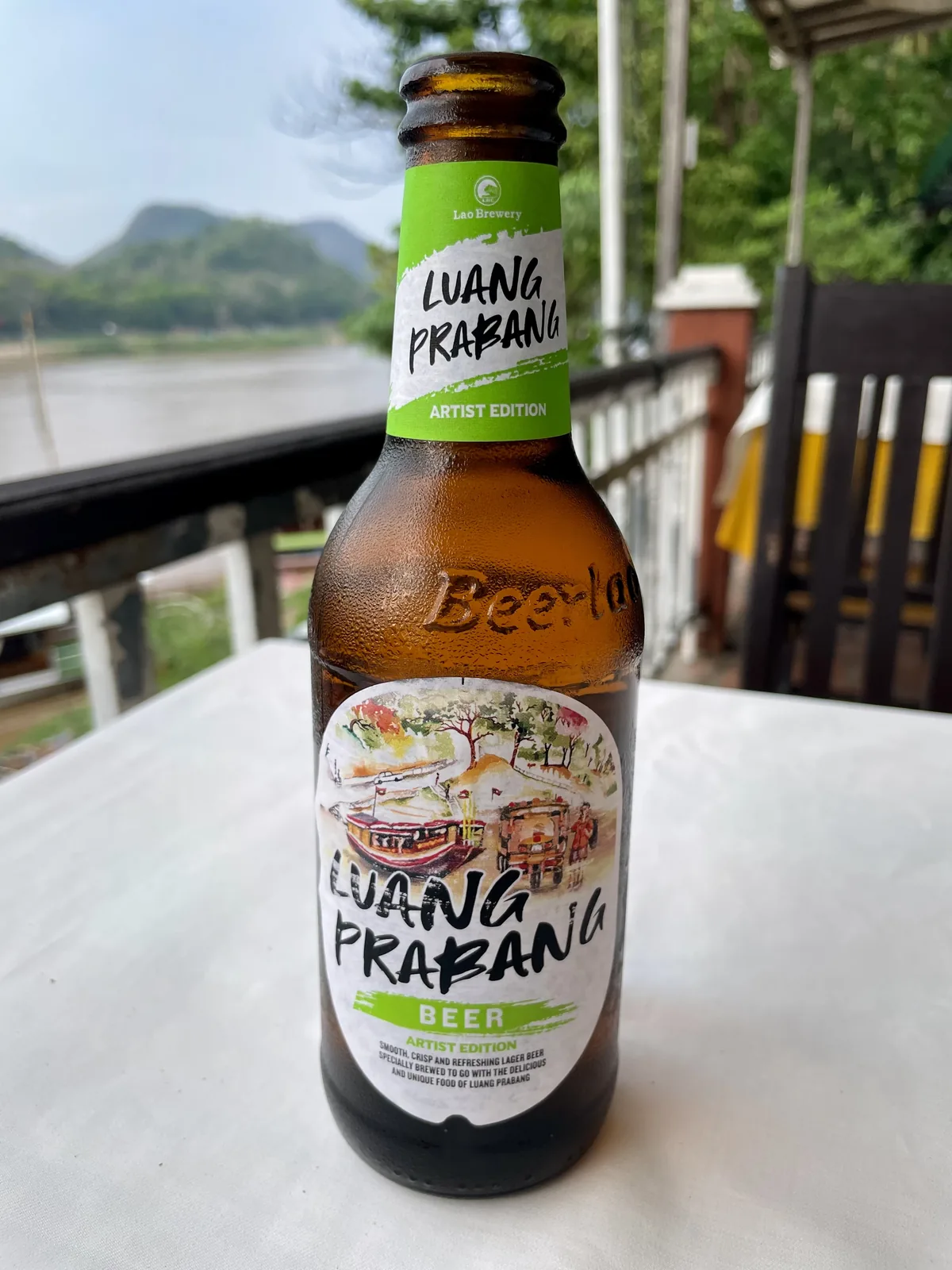 Luang Prabang Beer bottle on a terrace overlooking the Mekong River