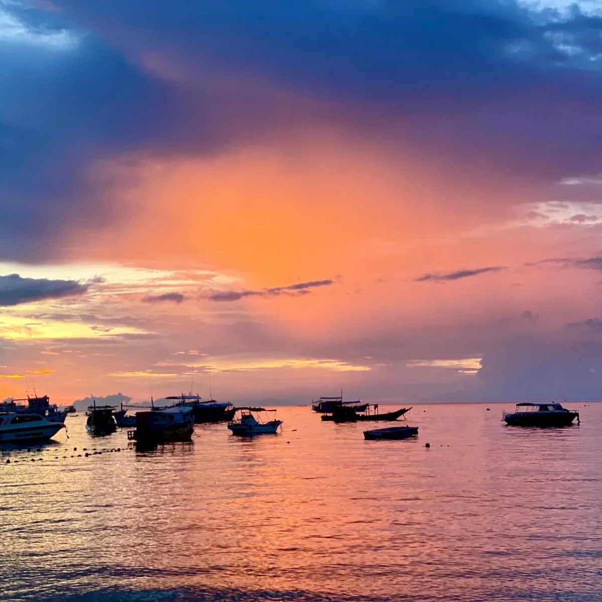 Sunset over the moored boats on Koh Tao, the sky going orange and pink