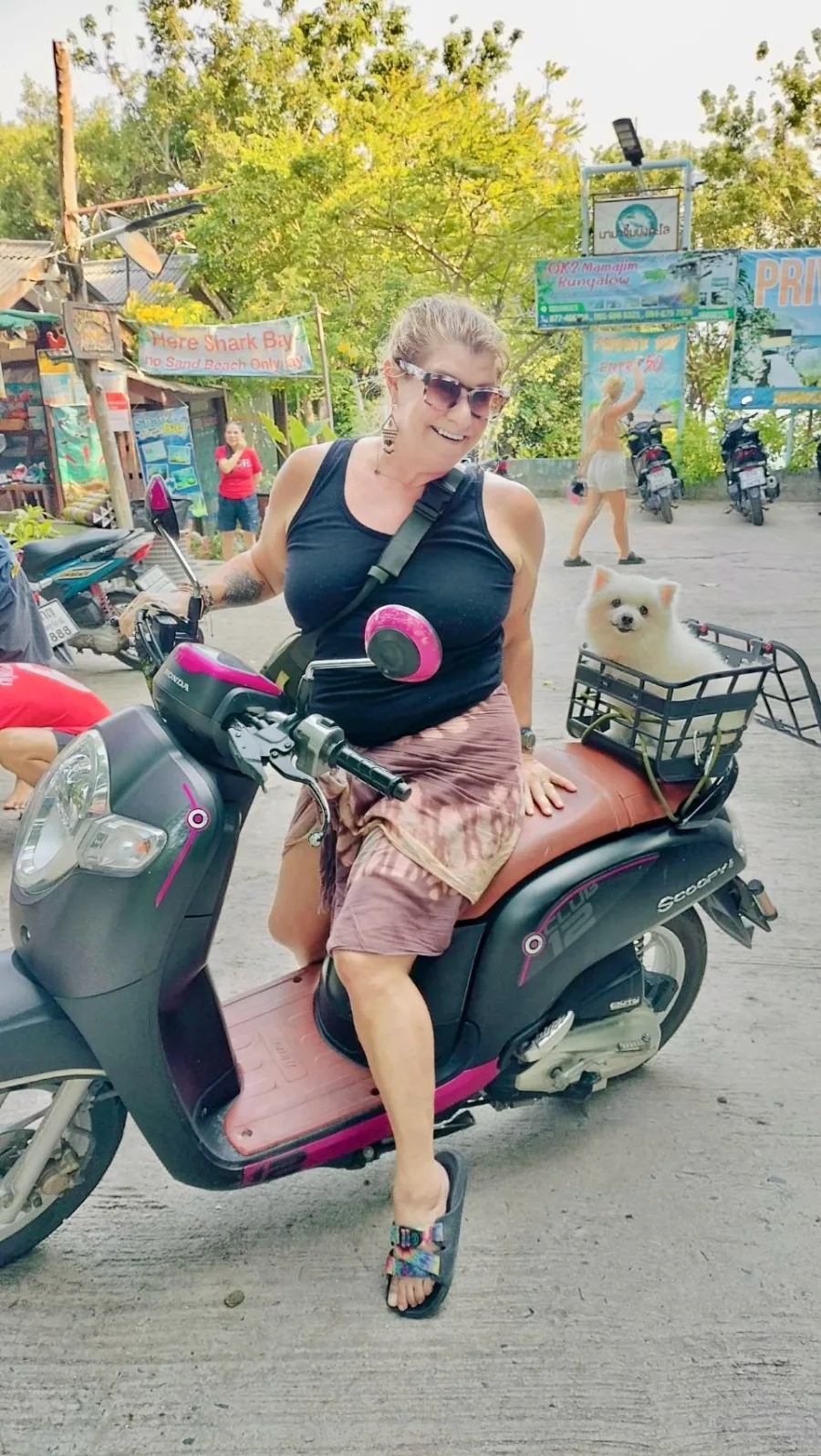 Jennifer, Gal Goes Solo founder, on her scooter with her dog by Shark Bay, Koh Tao, Thailand