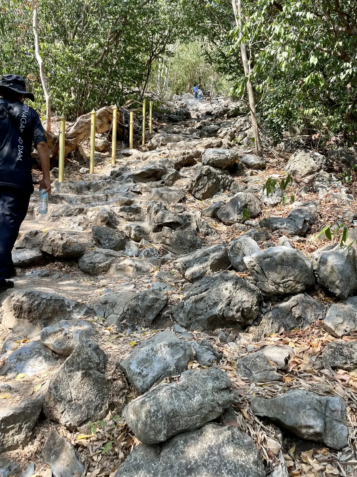 A steep, rocky and uneven trail climbing up to Phraya Nakhon Cave with a park ranger ahead