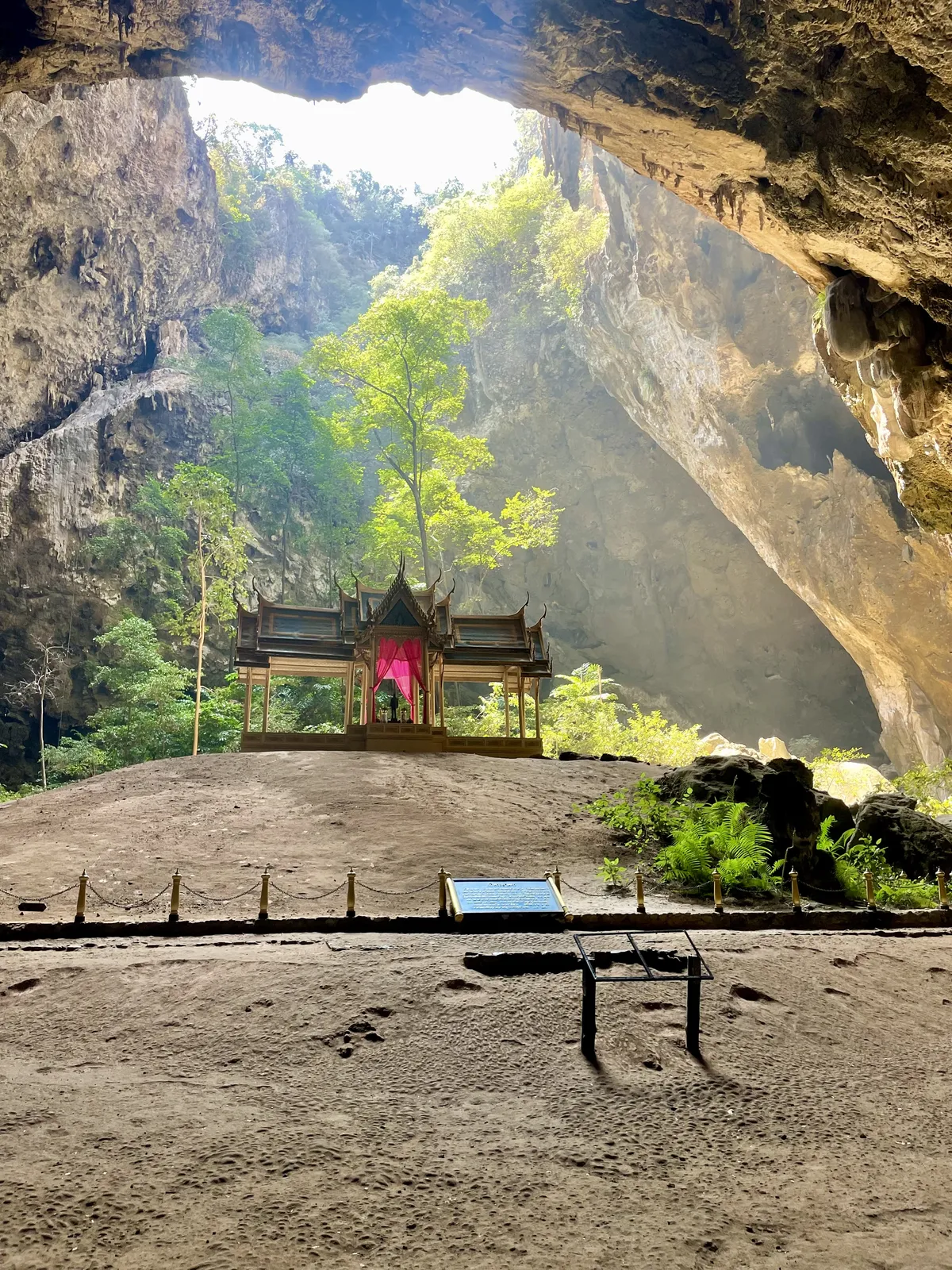 A beam of sunlight pouring through the cave opening onto the golden royal pavilion inside Phraya Nakhon Cave