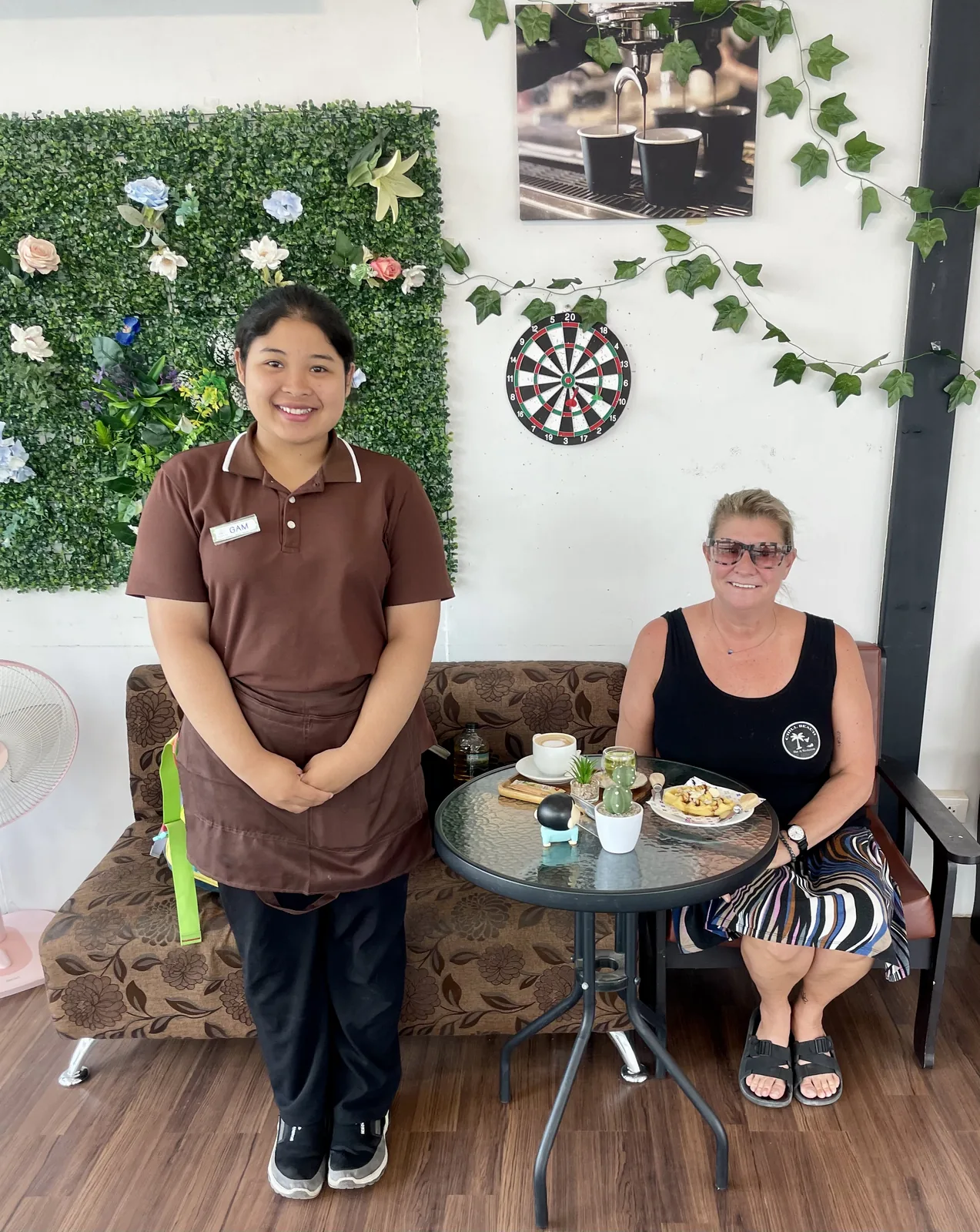 A Thai girl barista and an older woman sitting in a coffee shop in Thailand